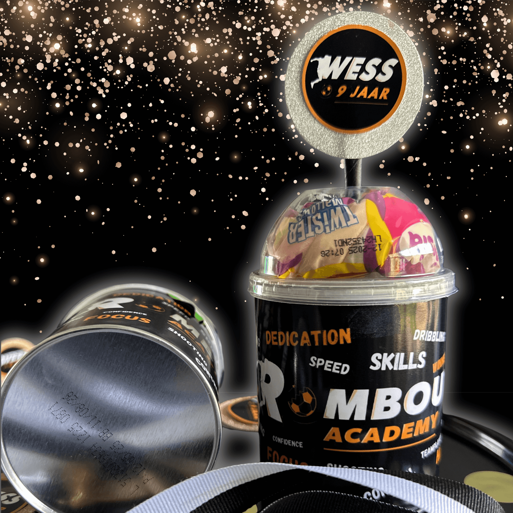 Personalized traktatie cup with Rombout Academy branding, transparent lid full of candy, and custom medal with name and age.